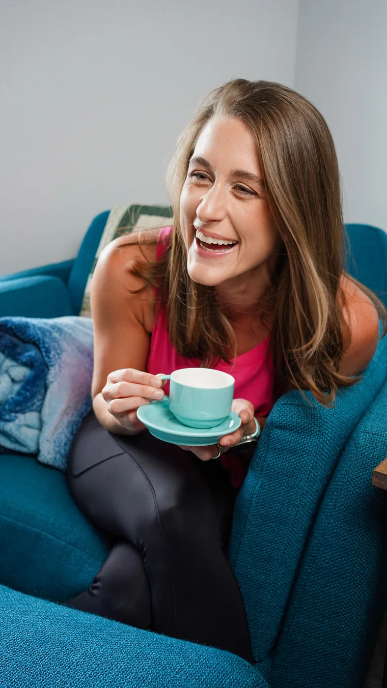 Becky smiling with a cup of coffee